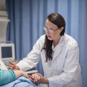 Helena tarkistaa potilaan vointia